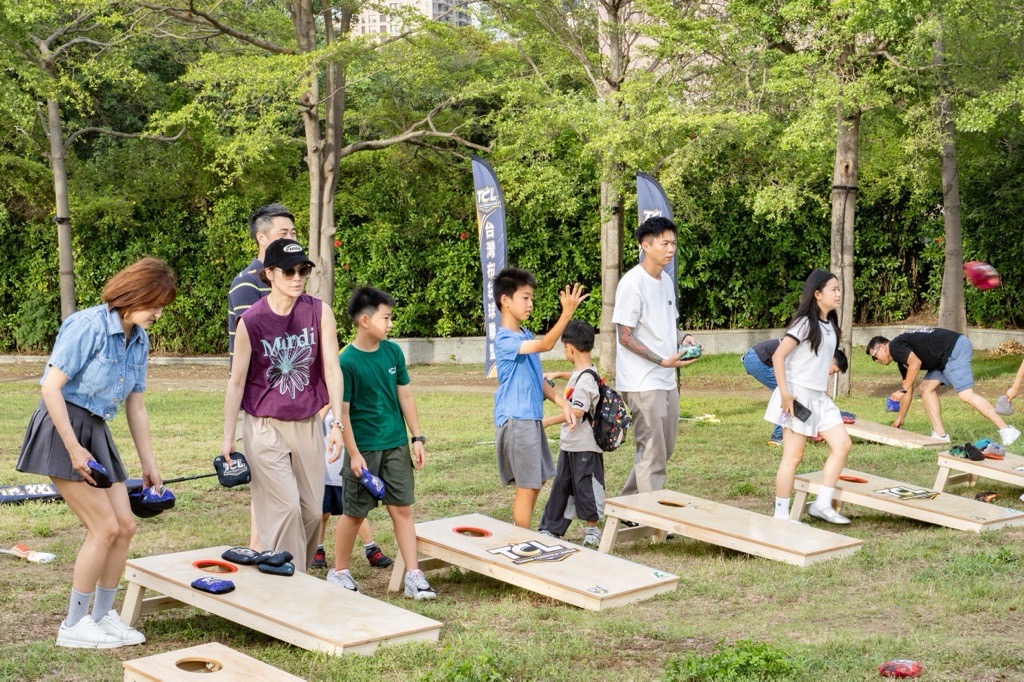 公園草地上大小朋友一起玩布袋球